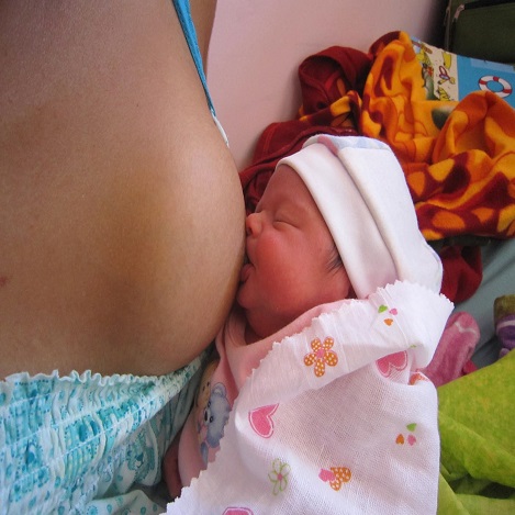 Recién nacido agarrado de forma adecuada con la boca bien abierta, el labio inferior evertido y el mentón apoyado en la mama. 